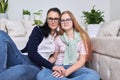 Friendly cheerful family, portrait of mom and teenage daughter, with green parrot