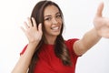Friendly cheerful young cute woman in red t-shirt smiling, tilt head extend arm to hold camera and take selfie, talking