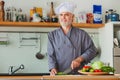 Friendly chef preparing vegetables in his kitchen