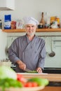 Friendly chef preparing vegetables in his kitchen