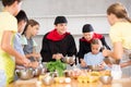 Friendly chefs in black uniform giving cooking lesson to group of tweens Royalty Free Stock Photo