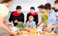 Friendly chefs in black uniform giving cooking lesson to group of tweens Royalty Free Stock Photo