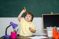 Friendly child in classroom near blackboard desk. Cute little preschool kid boy study in a classroom. Funny little kids Royalty Free Stock Photo