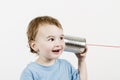Friendly child listening to tin can phone Royalty Free Stock Photo