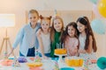 Friendly children embrace while pose near festive table, blow candles on cake, have party mood, celebrate birthday or special Royalty Free Stock Photo