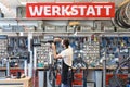 Friendly and competent bicycle mechanic in a workshop repairs a Royalty Free Stock Photo