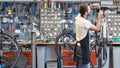 Friendly and competent bicycle mechanic in a workshop repairs a bike Royalty Free Stock Photo