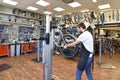 Friendly and competent bicycle mechanic in a workshop repairs a bike