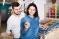 friendly couple examining various paints in paint store Royalty Free Stock Photo