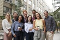 Friendly coworkers laugh to camera outside their workplace Royalty Free Stock Photo