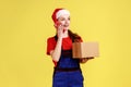 Friendly delivery woman talking on cellphone with client and accepting order, holding cardboard box Royalty Free Stock Photo