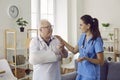 Friendly doctor giving her help and support to a senior patient with a broken arm Royalty Free Stock Photo