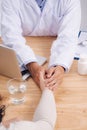 Friendly doctor hands holding patient hand sitting at the desk f Royalty Free Stock Photo