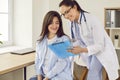 Friendly doctor showing report file with appointment to a young patient woman in medical clinic. Royalty Free Stock Photo