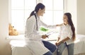 Friendly female pediatrician talking to a happy child during her medical checkup Royalty Free Stock Photo