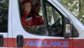 Friendly doctors in ambulance looking at camera, professional emergency service