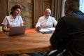 Friendly doctors and a client in are sitting at desk