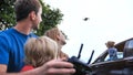 A friendly family launches a drone and controls it through the control panel.