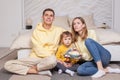 Friendly family, parents with child son sitting by the bed and holding bowl with popcorn