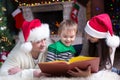 Friendly family reading book on Christmas evening Royalty Free Stock Photo