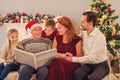 Friendly family viewing album on holiday Royalty Free Stock Photo