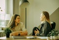 Friendly female colleagues having good relationships, pleasant conversation at workplace during coffee break Royalty Free Stock Photo