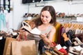 Friendly female customer selecting shoes in footgear center Royalty Free Stock Photo