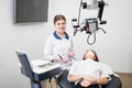 Friendly female dentist with woman patient before dental procedure with microscope in dental clinic Royalty Free Stock Photo
