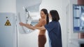 Friendly Female Doctor Explains the Mammogram Procedure to a Topless Adult Female Patient Undergoi Royalty Free Stock Photo