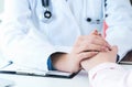 Friendly female doctor hands holding patient hand sitting at the desk for encouragement, empathy, cheering and support Royalty Free Stock Photo