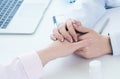 Friendly female doctor hands holding patient hand sitting at the desk for encouragement, empathy, cheering and support Royalty Free Stock Photo