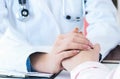 Friendly female doctor hands holding patient hand sitting at the desk for encouragement, empathy, cheering and support Royalty Free Stock Photo