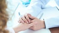 Friendly female doctor hands holding patient hand sitting at the desk for encouragement, empathy, cheering and support Royalty Free Stock Photo