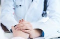 Friendly female doctor hands holding patient hand sitting at the desk for encouragement, empathy, cheering and support Royalty Free Stock Photo