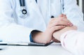 Friendly female doctor hands holding patient hand sitting at the desk for encouragement, empathy, cheering and support Royalty Free Stock Photo