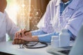 Friendly female doctor hands holding patient hand sitting at the desk. Royalty Free Stock Photo