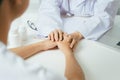 Friendly female doctor hands holding patient hand sitting at the Royalty Free Stock Photo