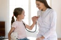 Friendly female doctor playing with little patient in clinic Royalty Free Stock Photo