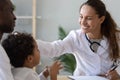 Friendly female doctor stroke head of cute african child boy Royalty Free Stock Photo