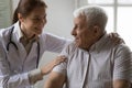 Friendly female doctor support encourage mature grey haired male patient Royalty Free Stock Photo