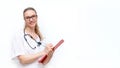 Friendly female doctor in white coat with phonendoscope makes notes on clipboard, isolated on white background. Medical Royalty Free Stock Photo