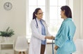 Friendly female gynecologist measuring the round belly of a pregnant woman at the examination room Royalty Free Stock Photo