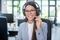 Friendly female helpline operator with headset in office Royalty Free Stock Photo