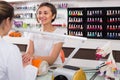 Friendly female manicurist filing and shaping nails in beauty salon