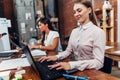 Friendly female office workers wearing formal workwear typing on laptop keyboard working in creative agency Royalty Free Stock Photo