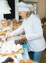 Friendly female seller offering sweets Royalty Free Stock Photo