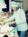 Friendly female seller offering sweets Royalty Free Stock Photo