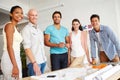 Friendly and focused. Portrait of a group of smiling designers gathered together around an office table to discuss their