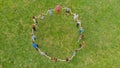 Friends in a circle holding hands make a round dance in the field. Royalty Free Stock Photo