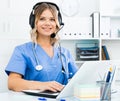 Friendly girl in headphones with microphone in medical call center
